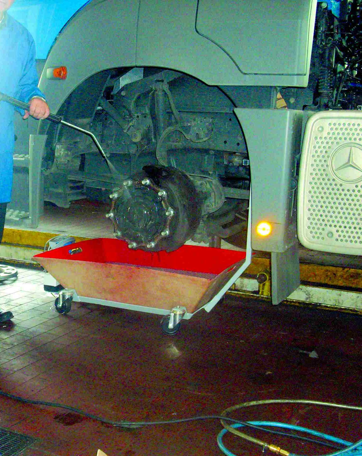 Cleaning truck brakes at the pit, with water collector for dirt water